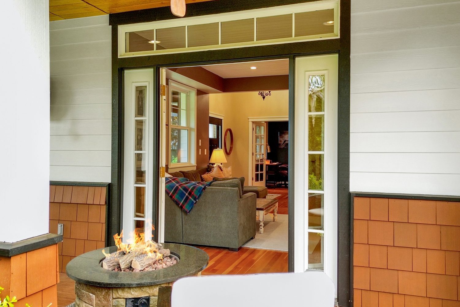 French doors open to a covered porch fire feature