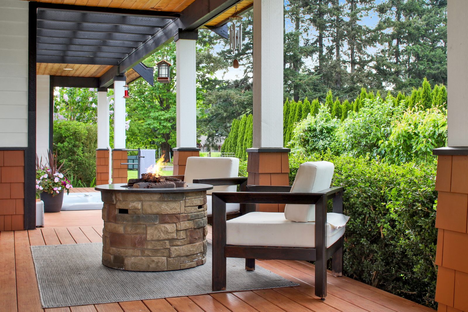 Covered porch seating with a fire table at Applegrove